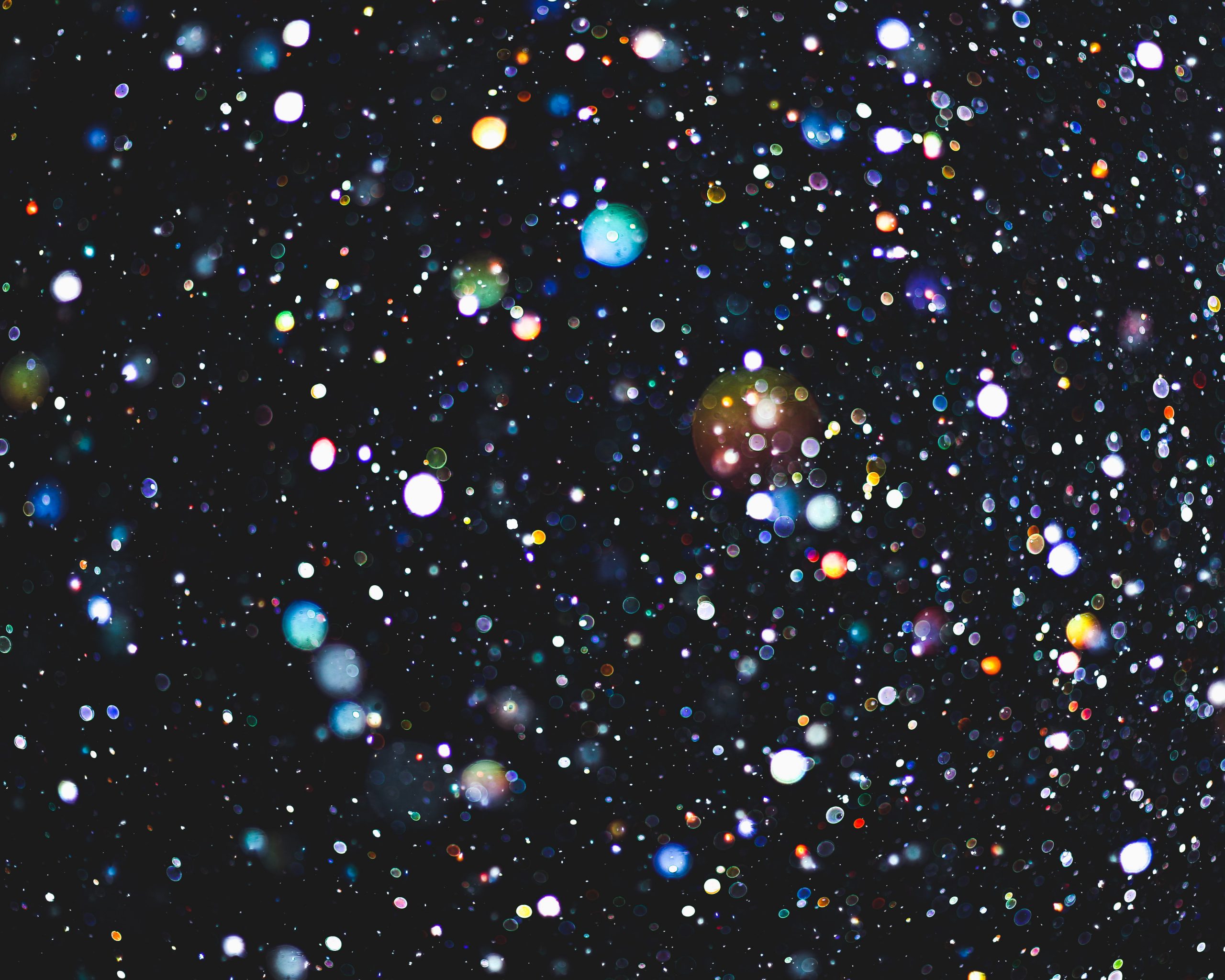 Bild - massvis av färgglada lysande cirklar mot svart bakgrund